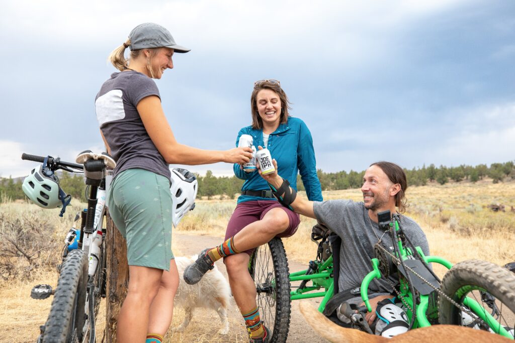 three mountain bikers having a beer after a ride