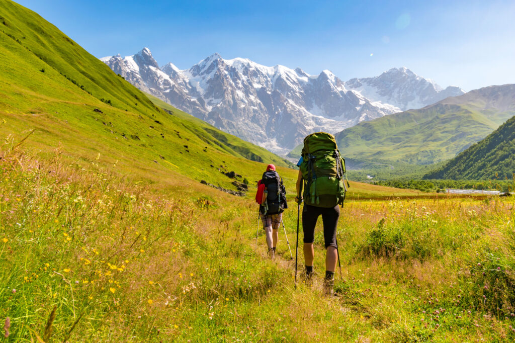 young active girls hiking in greater caucasus mountains, mestia district, georgia