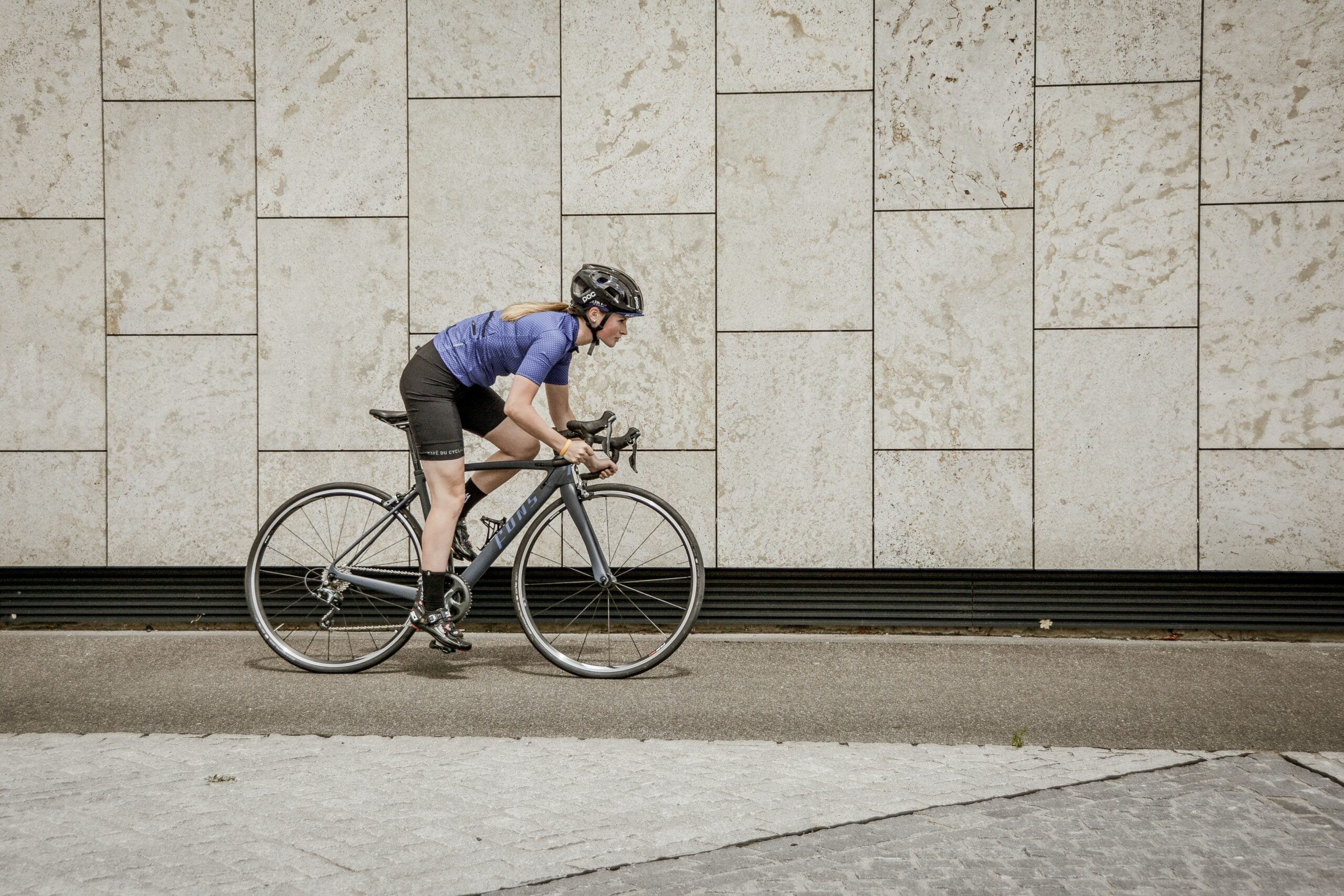 Woman cyclist on the road.|Bikepacking near a green field.