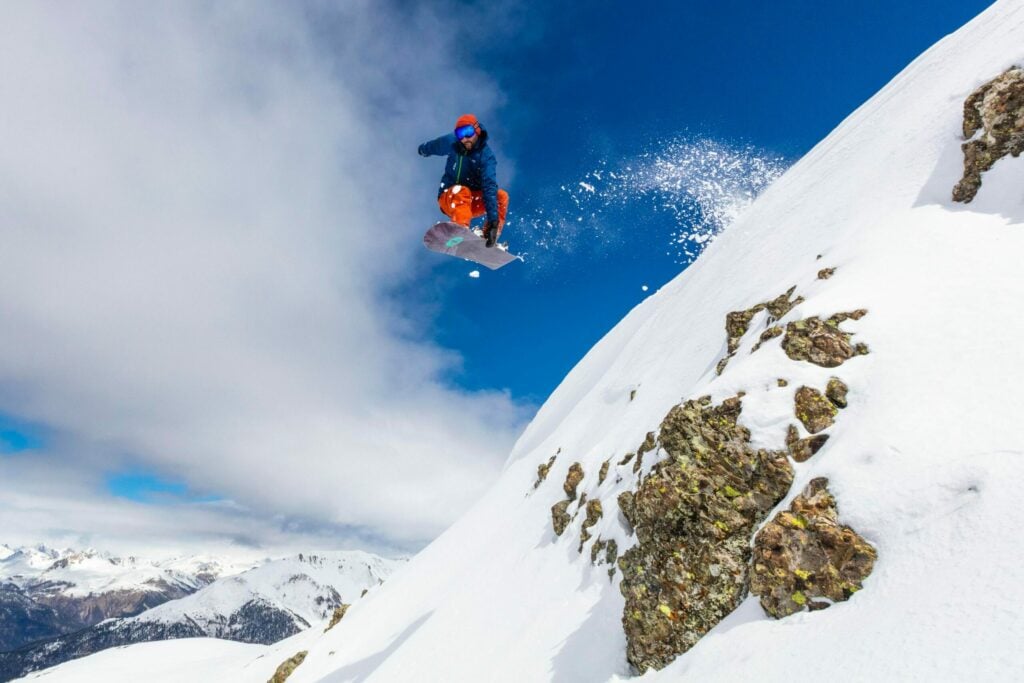 snowboarding jump with blue sky and steep slope|chef chopping peppers in the kitchen|two girls