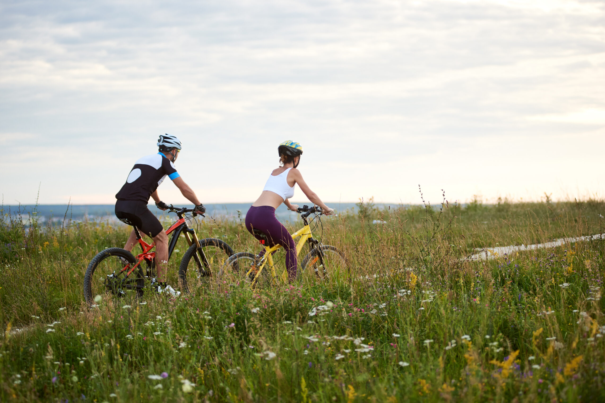 Two cyclists riding bikes on trail.|Young man mountain biking