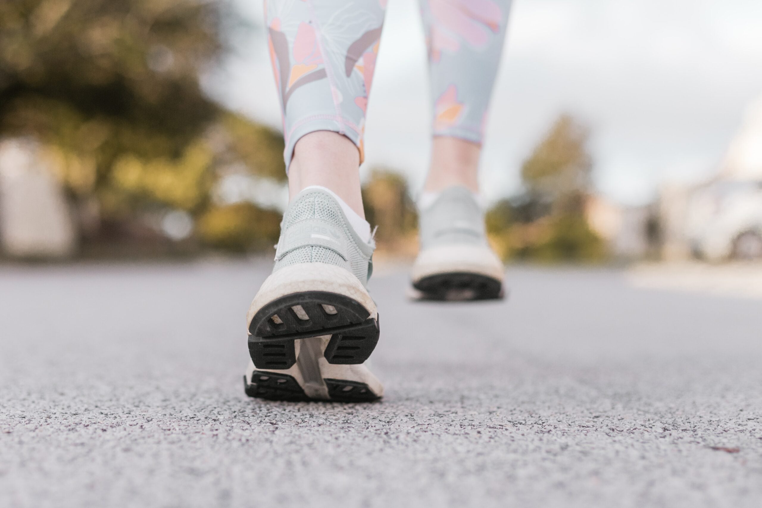 woman walking on pavement in grey shoes|Woman running on the road in the high desert country. Sagebrush and yellow flowers at the forefront.|Grandma and grandchild walking on a forest road.