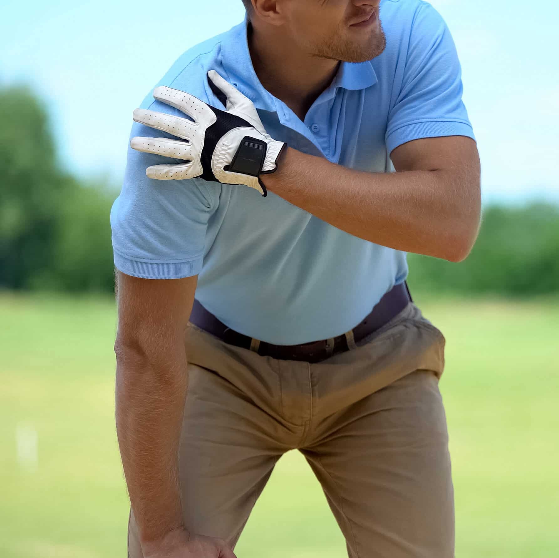 Young male golf player suffering terrible shoulder spasm after shot, trauma